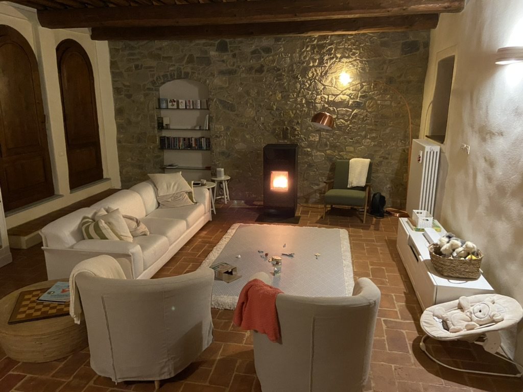 Living room with stone wall and stove